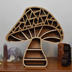 a wooden shelf sitting on top of a table next to a vase and other items