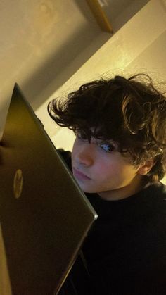 a young woman is looking at her laptop screen while sitting in front of the camera