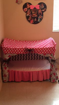 a child's bed in the corner of a room with minnie mouse decorations on the wall