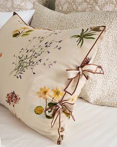 a white bed topped with lots of pillows