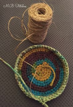 two spools of twine are next to a crochet dishcloth