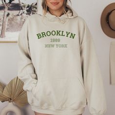 "Brooklyn Oversized Hoodie This oversized hoodie is the perfect way to show your love for Brooklyn. It's made of soft, heavyweight cotton and features a relaxed fit that's perfect for layering. The hoodie is available in a variety of colors, so you can find the perfect one to match your style. Please check all photos for details. Please note that due to monitor differences, the actual colors may vary slightly from what appears online. ----- DESIGN COLOR ----- The following shirt colors come with a WHITE design: Black, Red, Dark Gray Heather, Heather Navy, Heather Maroon, Forest, Heather Deep Teal, Heather Mauve, Heather Olive. The following shirt colors come with a BLACK design: White, Heather Peach, Light Gray, and Pink. If you have a specific request for the design color, you can add a n Hip Hop Hooded Sweatshirt For College, Oversized Winter College Hoodie, Oversized Vintage Hoodie For Fall, Oversized Winter Hoodie For College, Hip Hop College Hoodie, Throwback Hoodie With Graphic Print, Retro Long Sleeve Hoodie With Letter Print, Throwback Graphic Print Hoodie, Retro College Hoodie With Drawstring Hood