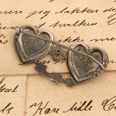 "The listing is for a Victorian English Mizpah Brooch. The brooch is in the shape of two joined hearts brooch with hand engraved and applied leaf decoration. The brooch has the word MIZPAH applied to the heart and has an engraved prayer \" The Lord Watch Between Me and Thee When We Are Absent One From Another\" (from Genesis 31:49). Weighs: 3.2 grams Measurement: It measures 0.8055 inches long and 1.5515 inches wide. Marks: Anchor Lion d marks. A.G.G. makers mark (possibly for Alfred George Grif Heirloom Engraved Brooches For Gifts, Antique Heart Brooch For Wedding, Antique Heart-shaped Wedding Brooch, Collectible Vintage Heart-shaped Brooch, Vintage Heart-shaped Collectible Brooch, Vintage Heart Shaped Collectible Brooch, Antique Heart-shaped Brooch For Gift, Antique Heart-shaped Brooches As Gifts, Antique Heart-shaped Brooches For Gifts