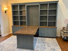 an office desk with built in bookcases and drawers on the carpeted floor