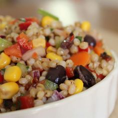 a white bowl filled with corn and vegetables