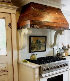 a kitchen with an oven, stove top and cabinets in it's center area