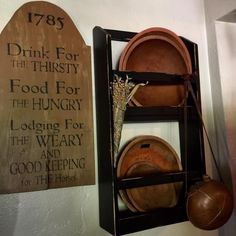 a shelf with pots and pans on it next to a sign that says drink for the thirsty food for the hungry