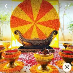 an arrangement of vases with flowers on the floor and in front of a large orange ball