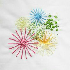 four different colored sprinkles on a white cloth with green and blue beads