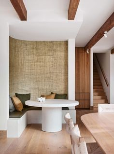 a white table sitting in the middle of a living room next to a stair case