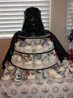 a star wars themed cake and cupcakes on a table