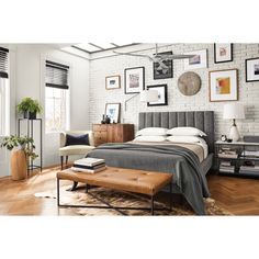 a bed sitting in a bedroom next to a wooden table with a lamp on top of it