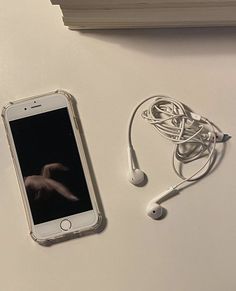 an iphone and ear buds on a table