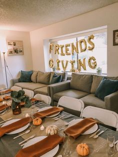 a living room filled with lots of furniture next to a table covered in plates and place settings