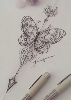 some pens are sitting on top of a piece of paper with a butterfly drawn on it