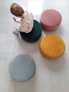 a small child sitting on top of three stools