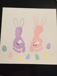 two bunny handprints on a piece of paper with easter eggs painted on them