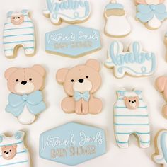 baby shower cookies are arranged on a white surface with blue and pink decorations, including teddy bears