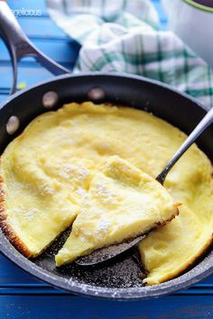 an omelet in a skillet with two slices cut out