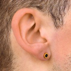 a close up of a man's ear with an earring in the middle