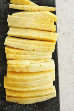 sliced up cheese sticks on a black cutting board