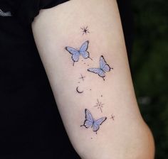 three blue butterflies with stars and crescent moon tattoo on the left side of the arm