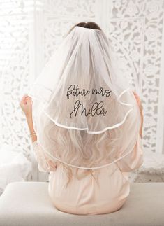 the back of a woman's head with her veil over her head that says future mrs mia