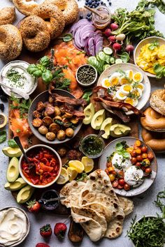 several different types of food are spread out on a table with plates and utensils