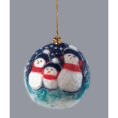 an ornament with three snowmen on it