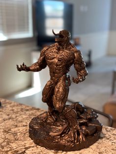 a bronze statue of a man with horns on top of a marble counter in a living room