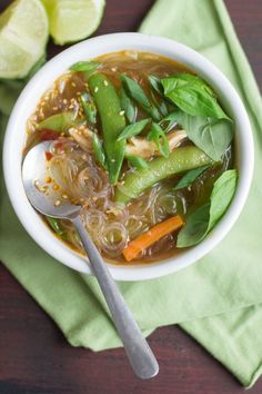 a white bowl filled with soup and veggies on top of a green napkin