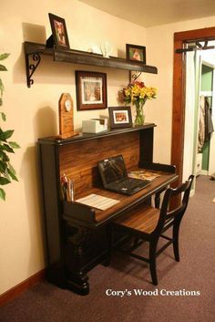 a desk with a laptop computer on top of it next to a wall mounted shelf