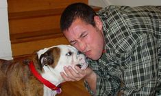 a man is petting his dog on the nose while he lays on the floor