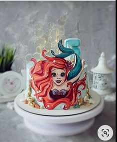 there is a cake with a little mermaid on it