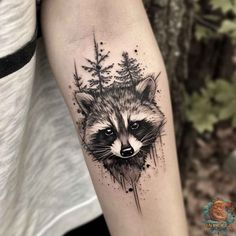 a raccoon tattoo on the arm with pine trees and watercolor splashes