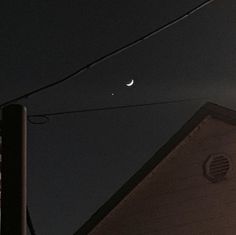 the moon and venus are visible in the night sky over a house with power lines