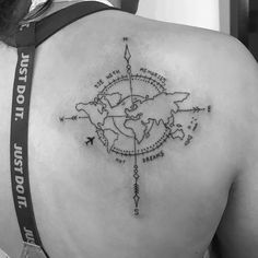 a woman's back with a compass tattoo on it