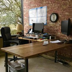 an office with brick wall and wooden desk