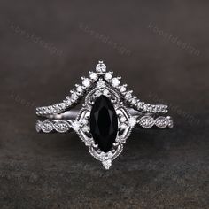 a black and white diamond engagement ring with an intricate design on the side, set in 18k white gold