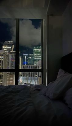 a bedroom with a view of the city at night