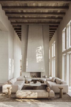 a large living room with high ceilings and wooden beams on the ceiling is filled with furniture