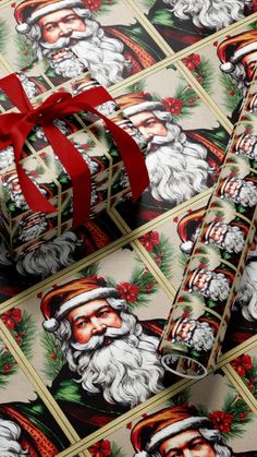 christmas wrapping paper with santa claus on it and red ribbon tied around the gift box