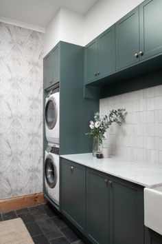 a washer and dryer in a room with green cabinets