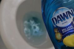 a close up of a bottle of detergent on a toilet seat with the lid down