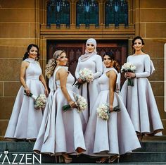 a group of bridesmaids posing for a photo in front of a church door