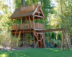 a tree house built into the side of a hill with a swing set and slide