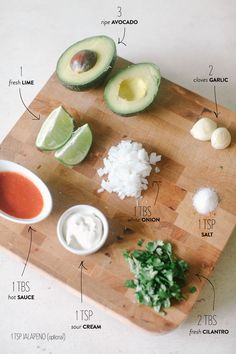 an avocado cut in half on a cutting board with ingredients labeled around it