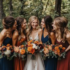 a group of women standing next to each other in front of trees and holding bouquets