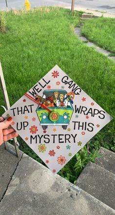 a graduation cap that says well game wraps up this mystery on the side of a sidewalk