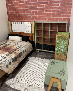 a bed sitting next to a brick wall with a wooden foot board on top of it